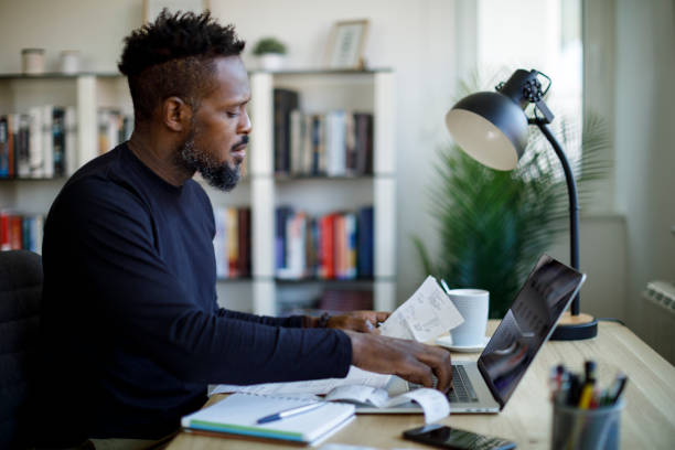 homme calculant le budget et les finances - formulaire des impôts photos et images de collection