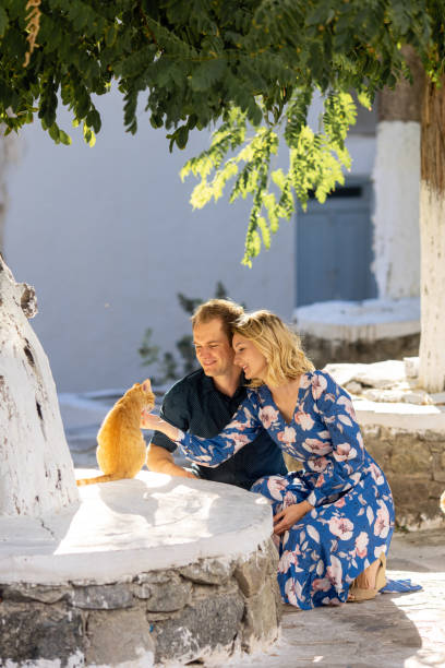 istock couple playing with a cat on a summer day 1354077762
