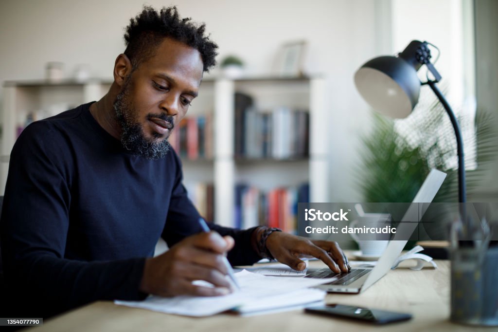 Man working at home Writing - Activity Stock Photo