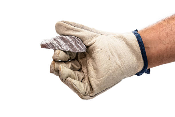 istock miner hand with protective glove holding silver color ore, metallic stone, isolated white background. Steelmaking or mining concept 1354077888