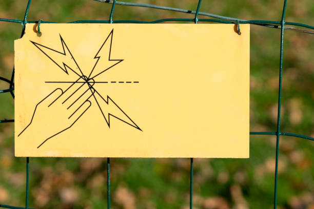 istock yellow electric shock warning signpost on fence. 1354078914