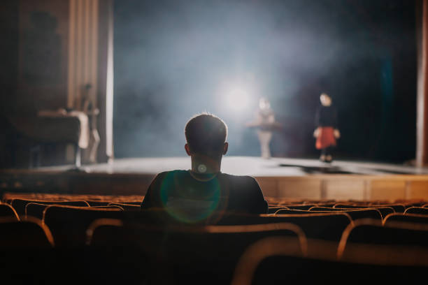 One spectator watching the rehearsal of ballet dancer on stage One spectator sitting and watching the rehearsal of ballet dancer on stage theatrical performance stock pictures, royalty-free photos & images