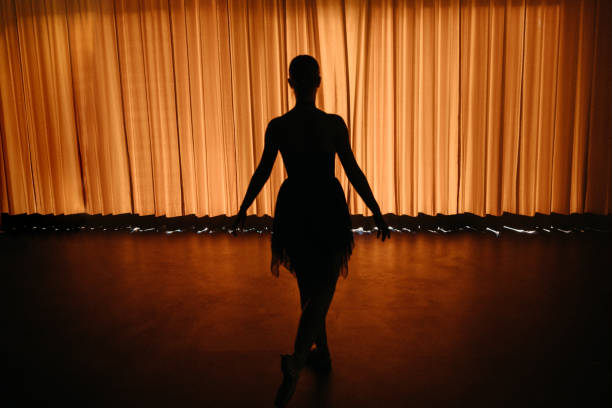 rückansicht der balletttänzerin, die hinter vor dem vorhang hinter der bühne wartet - innenraum gegenlicht teenager dunkel rücken stock-fotos und bilder