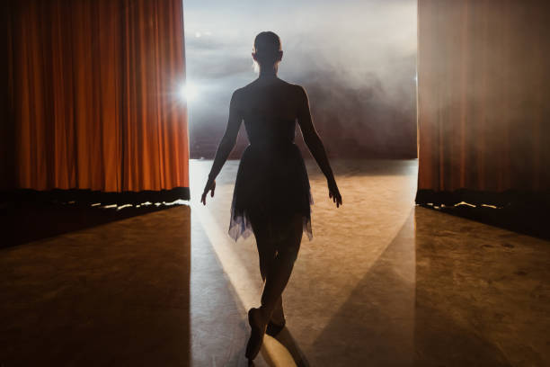 Rear view of ballerina walks into the stage after the curtains open Rear view of ballerina walks into the stage after the curtains open of theater color image performing arts event performer stage theater stock pictures, royalty-free photos & images
