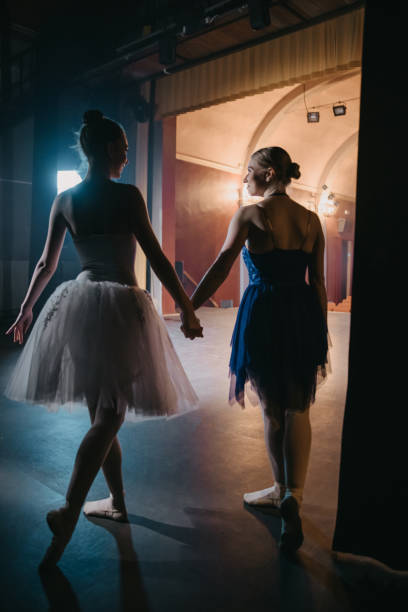 istock Rear view of two ballerinas walking on stage 1354079870