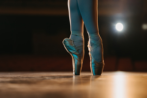 Close up of ballerina en pointe on stage of theater