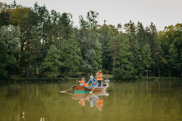 istock Grandfather sitting with grandsons in rowing boat 1354081524