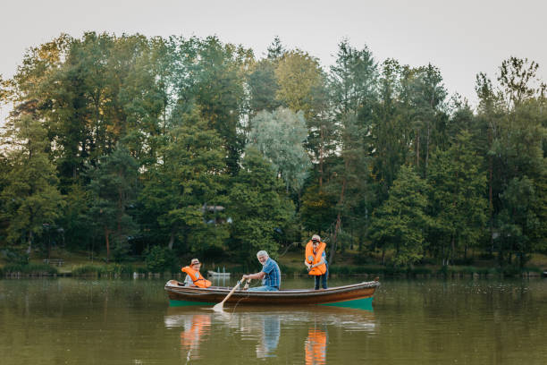 istock Grandfather sitting with grandsons in rowing boat 1354081537