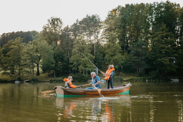 Grandfather sitting with grandsons in rowing boat