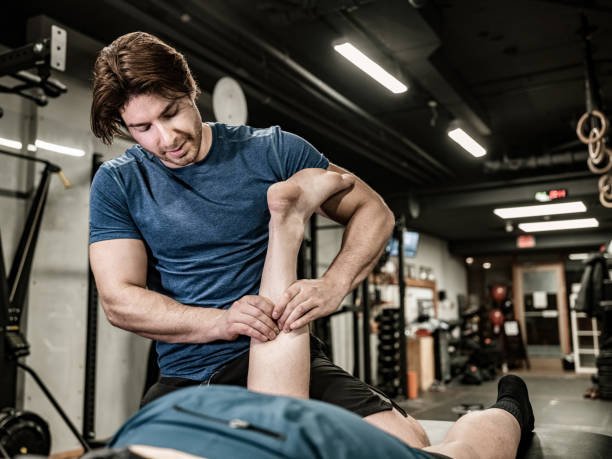 istock Male massage therapist doing massage at the gym 1354081562