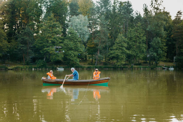 istock Grandfather sitting with grandsons in rowing boat 1354081565