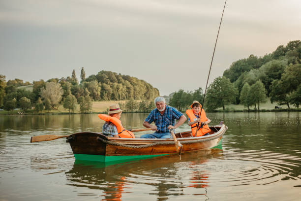 istock Grandfather sitting with grandsons in rowing boat 1354081586
