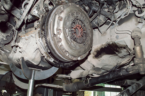 The process of replacing the clutch on a car hung on a lift in an auto repair shop