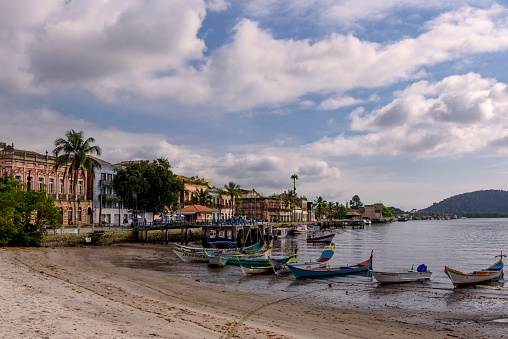 Paranaguá, PR, Brazil - November 17, 2021: Canoes moored on the pier in front of historic mansions