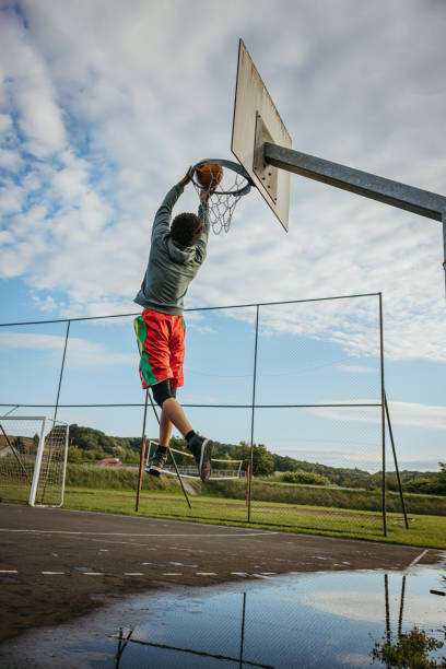 istock Basketball player slam dunking the ball 1354083486
