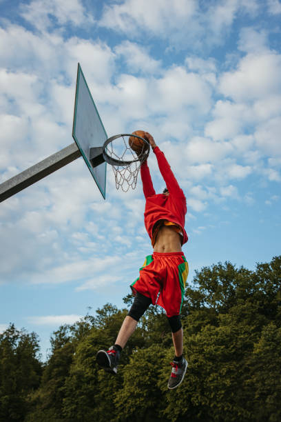 istock Basketball player slam dunking the ball 1354083511