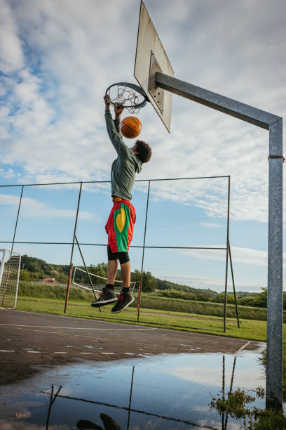 istock Basketball player slam dunking the ball 1354083531