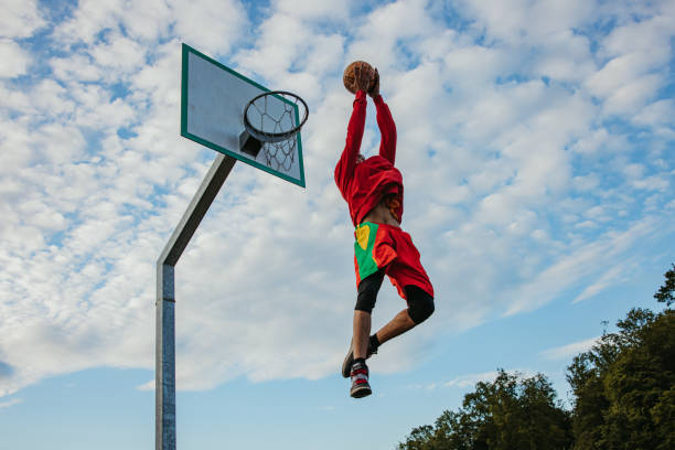 istock Basketball player slam dunking the ball 1354083577