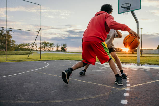 jogador de basquete defendendo bola do adversário - basketball child dribbling basketball player - fotografias e filmes do acervo