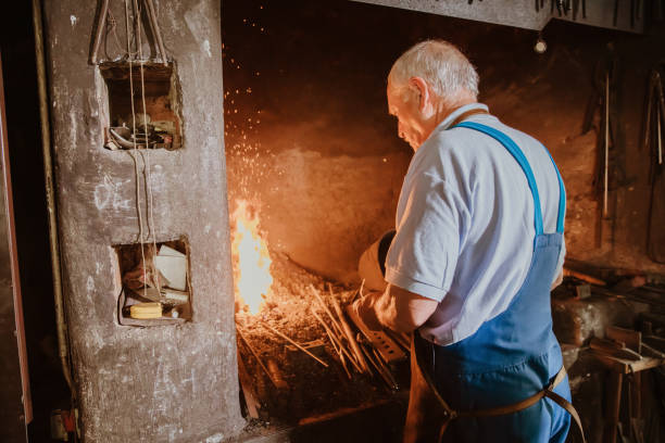 istock Senior blacksmith heating the metal 1354084322