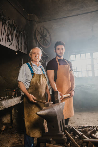 istock Portrait of two blacksmith holding hammer 1354084697