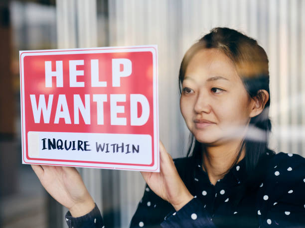 istock Business Owner Putting Up Help Wanted Sign 1354085715