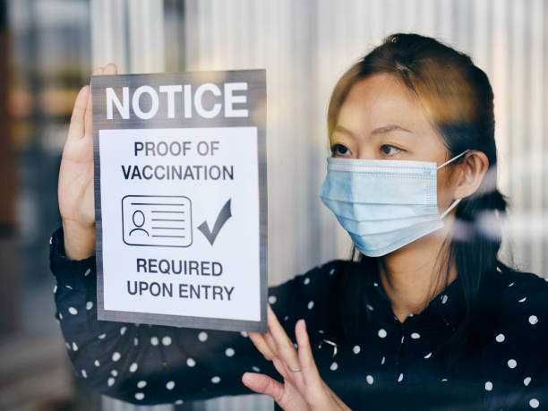 istock Business Owner Wtih Vaccine Mandate Sign 1354085732