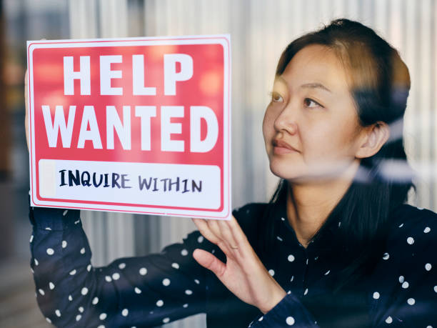 istock Business Owner Putting Up Help Wanted Sign 1354085735