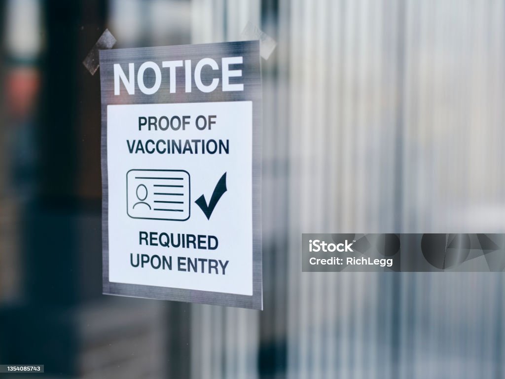 Business Wtih Vaccine Mandate Sign A business with a sign requiring proof of vaccination. Vaccination Stock Photo