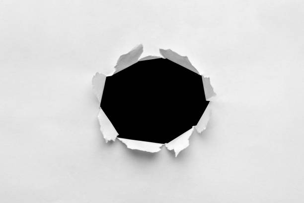 istock Paper sheet with black ragged hole 1354088647