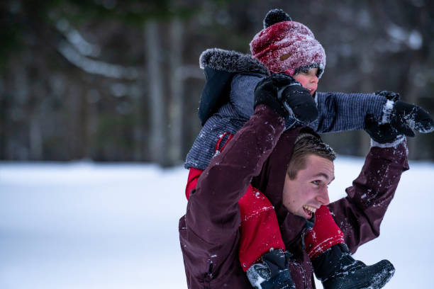 family playing outside during winter. - foto’s van jongen stockfoto's en -beelden