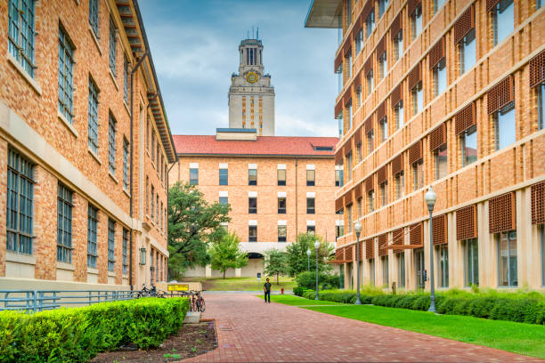 Student walks on the University of Texas campus in Austin, Texas, USA on a cloudy day.