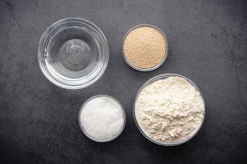 Flour, yeast, sugar, and salt in a dark background