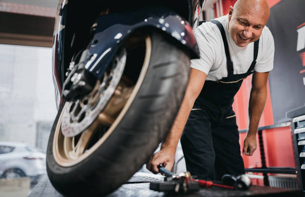 istock Repairman repairs motorcycle in store 1354093548