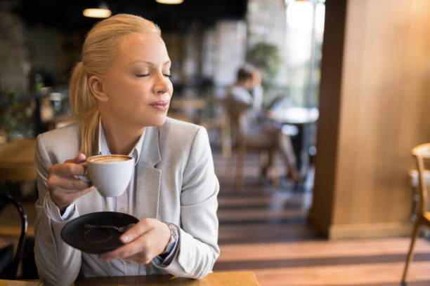 istock Joyful businesswoman drinking coffee at cafe. 1354095073