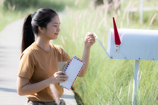 Teenage Girl collecting mail from mailbox