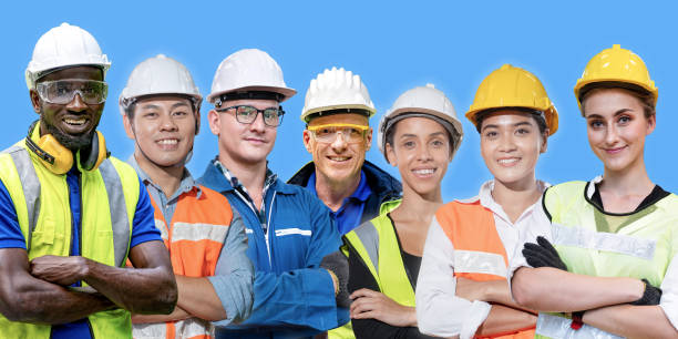 istock group workers engineering standing with confident with blue working suite dress and helmet in front of blue background. Concept of smart industry worker operating. Diversity of people of industry. 1354102678