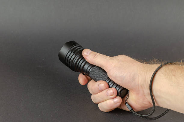 istock A man is holding a black LED hand flashlight. 1354105060