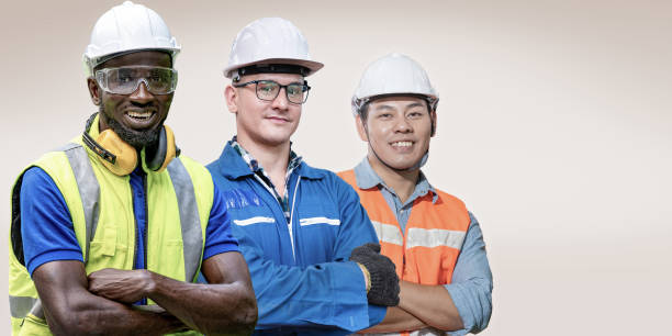 istock group workers men engineering standing with confident with blue working suite dress and helmet in front of blue background. Concept of smart industry worker operating. Diversity of people of industry. 1354106436