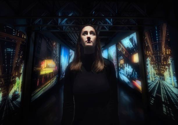 This photograph shows a woman standing in the middle of city lights and images, looking upwards towards the future.