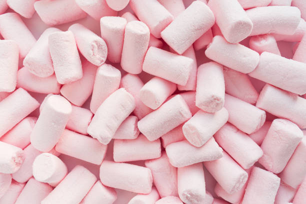 istock Lots of pink marshmallows are scattered over the surface. Close up. Selective focus. 1354112561