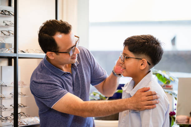 istock Indian father and son choosing eyeglasses in optics store 1354118292