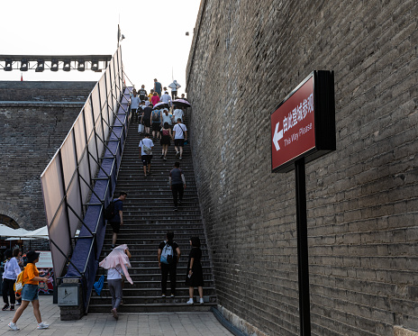 Xi'an, China - July 17, 2021: Stairs to Yongning Gate (South Gate) of the City Wall with many tourists in Xi'an, constructed during the early years of the Sui Dynasty and the landmark of the city.