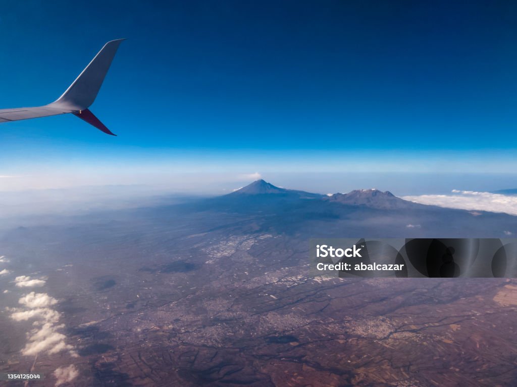 Popocatepetl and Iztaccihuatl volcanoes, Mexico Popocatepetl and Iztaccihuatl volcanoes seen from an airplane flying over Puebla state Aerial View Stock Photo