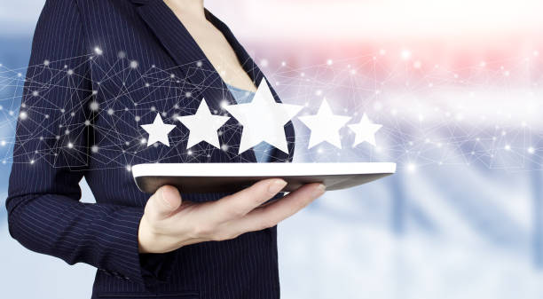 istock Increase rating or ranking, evaluation and classification concept. Hand hold white tablet with digital hologram five stars sign on light blurred background. Product service evaluation concept. 1354132784