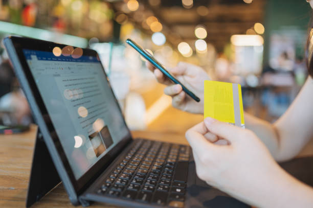 istock Asian woman Syncing a credit card to a tech device such as a smartphone or tablet Tapping a credit card to making payment online internet banking 1354136030