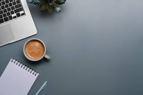 istock Cup of coffee, laptop computer and notepad on gray background. 1354139533