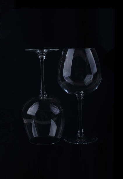 istock Silhouette of two wine glasses isolated on black 1354141900