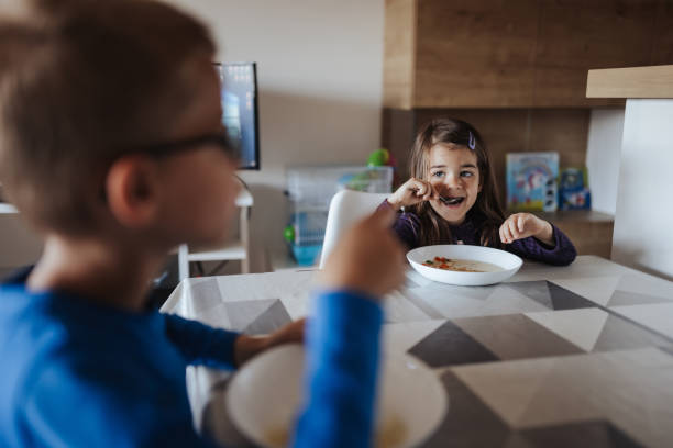 istock Brother and sister having lunch at home 1354142814