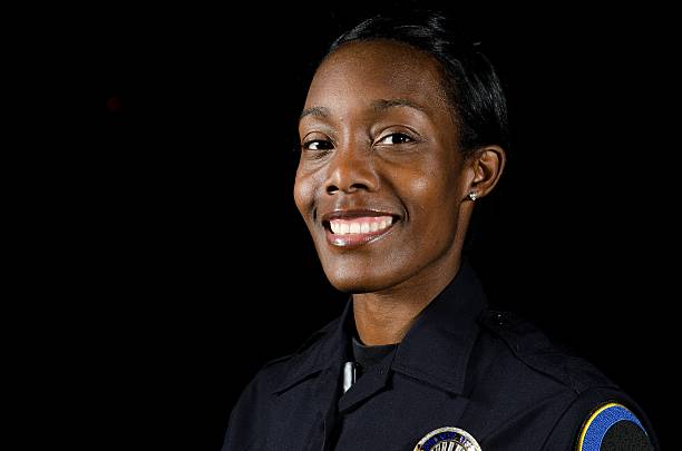 Female officer A female officer smiling in the night during her shift. female police officer stock pictures, royalty-free photos & images